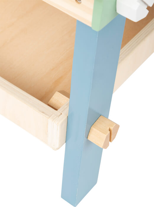 Nahaufnahme einer Holzschublade mit blauem Bein und Holzverriegelungsmechanismus im skandinavischen Design.