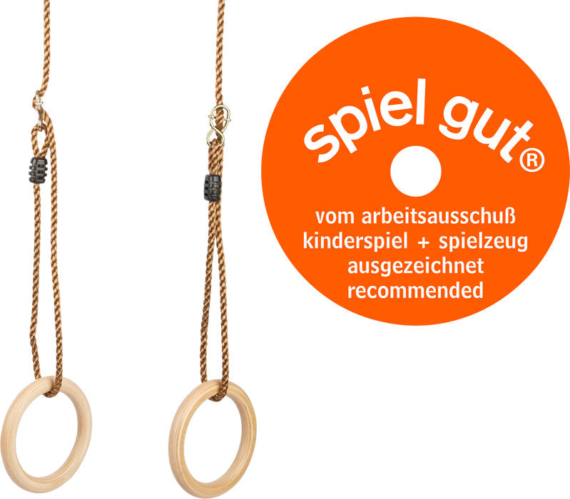 Zwei hölzerne Turnringe, die an verstellbaren Bändern neben einem runden orangefarbenen „Spiel gut“-Empfehlungsschild hängen, perfekt für Schaukelspaß und aktives Spielen.