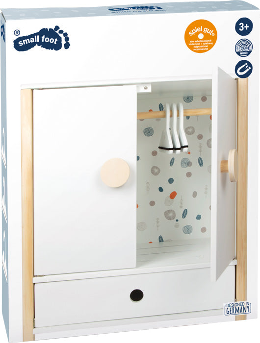 Spielzeugkleiderschrank mit Schiebetüren, einer Kleiderstange und drei Kleiderbügeln für Puppenkleidung – ein Kleiderschrank aus Holz in einem weißen Karton mit der Aufschrift „small foot“.
