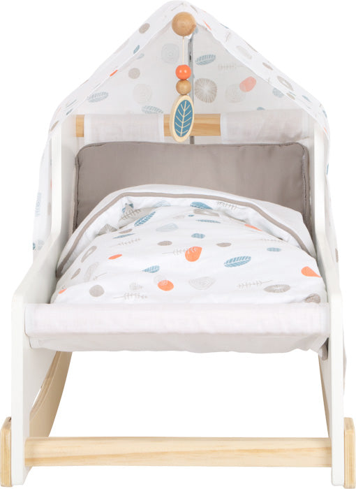 Weiße Puppenwiege aus Holz mit Baldachin, Bettzeug und Mobile mit Blättermuster in sanften Farben – mit charmantem skandinavischem Design für einen zeitlosen Kinderzimmer-Look.