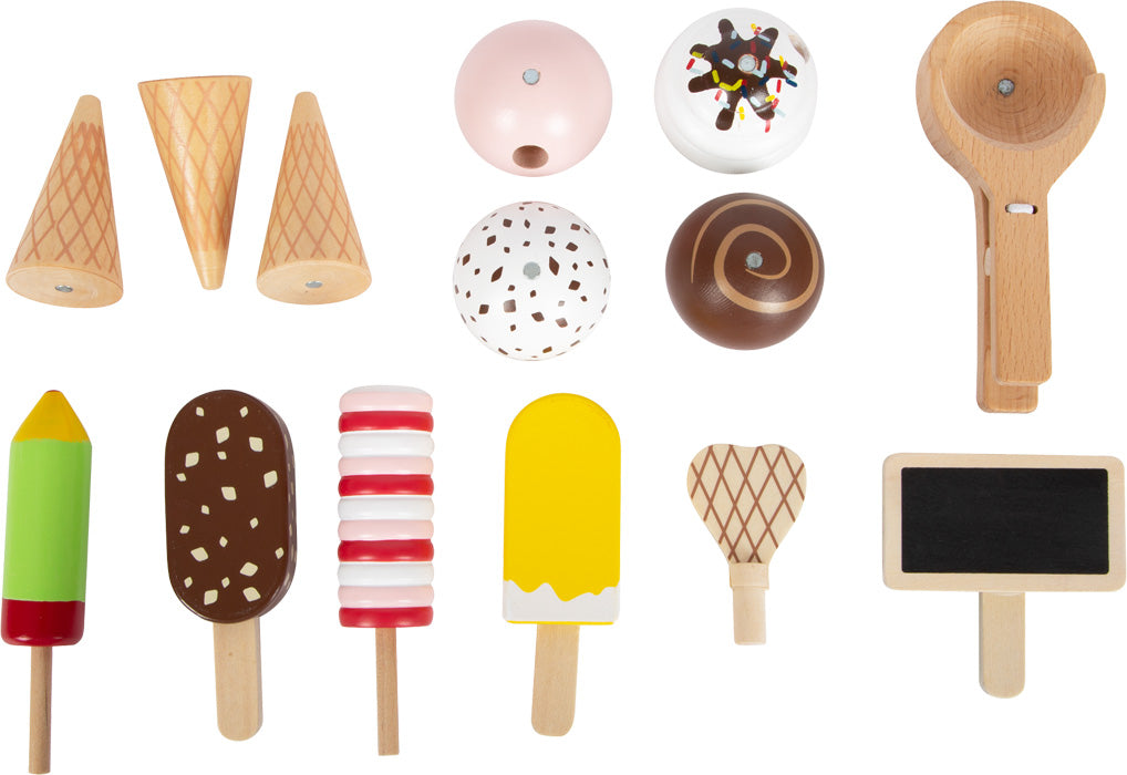 Verschiedene Spielzeug-Eissorten aus Holz, Eis am Stiel, Waffeln, ein Eiskugelportionierer und eine Kugel auf weißem Hintergrund angeordnet – perfekt für kreatives Rollenspiel Eis.