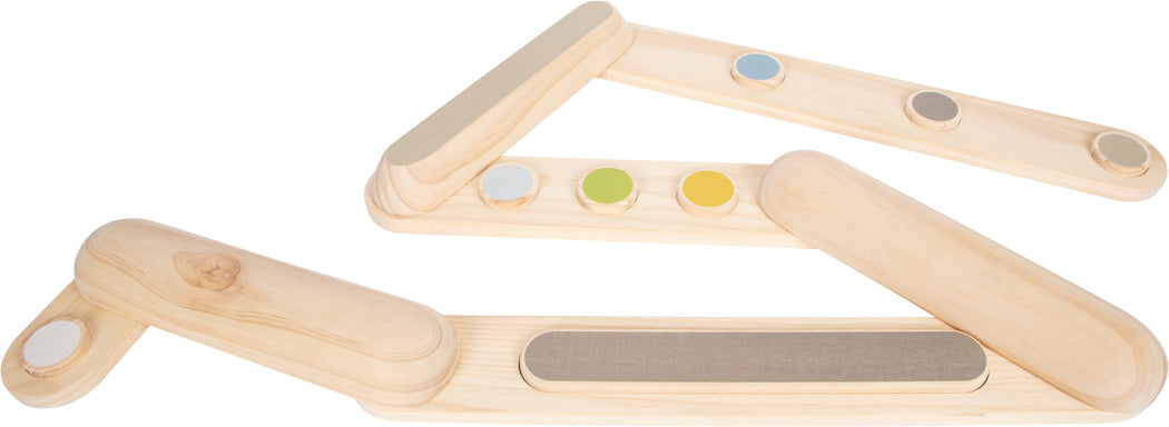 Sensorische Holztafeln mit farbigen und strukturierten Kreisen helfen bei der Entwicklung des Gleichgewichtssinns, während Kinder Balancierpfade auf weißem Hintergrund erkunden.