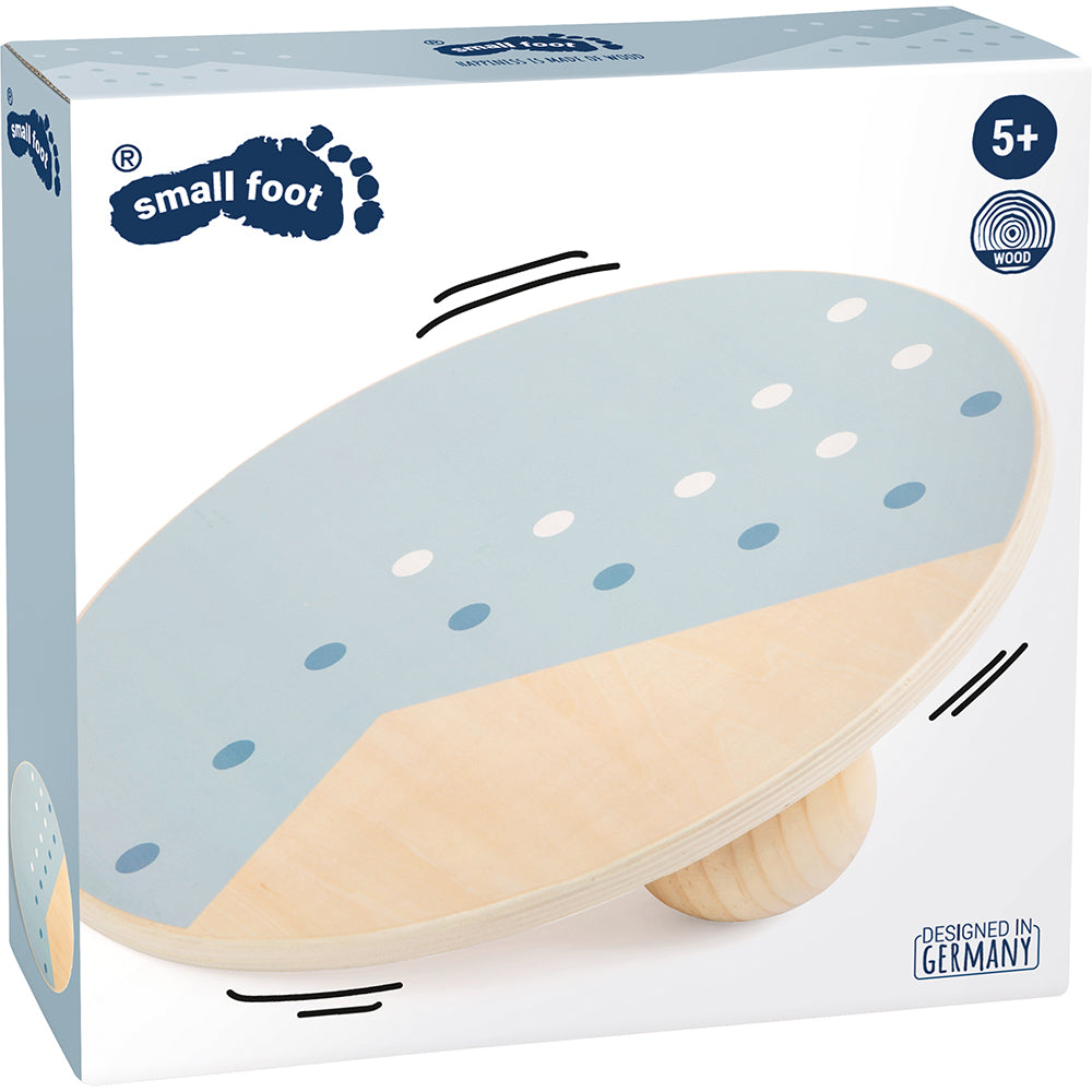 Box mit einem runden Balanceboard aus Holz mit blauen und weißen Punkten, ideal für Bewegungstraining und geeignet für Kinder ab 5 Jahren.