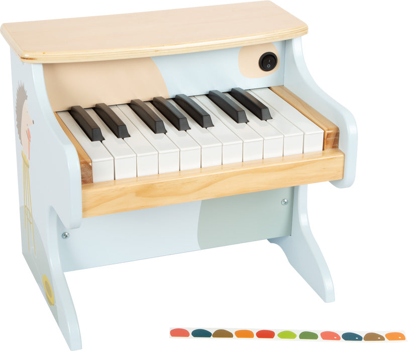 Ein kleines elektronisches Holzklavier mit schwarzen und weißen Tasten, bunten Notenaufklebern vorne und kindgerechten Motiven – perfekt für die musikalische Früherziehung.