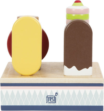 Hölzerne Stieleis in Gelb und Braun ruhen auf einem gemusterten Eisständer mit der Aufschrift „Frisch“, perfekt für jede Kinderküche.