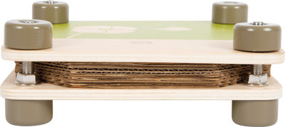 Eine Nahaufnahme einer kleinen Blumenpresse aus FSC®-zertifiziertem Holz mit vier grauen Rädern und gestapelten Kartonschichten in der Mitte.