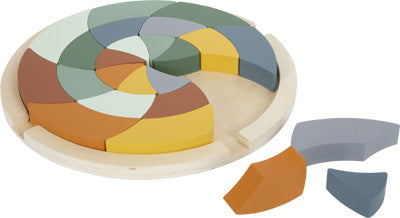 Spiralförmiges Farbenpuzzle aus Holz mit mehrfarbigen, gebogenen Teilen, von denen einige außerhalb der runden Schale platziert sind – eine spielerische Art, Formen und Farben zu entdecken, inspiriert von der Montessori-Pädagogik.