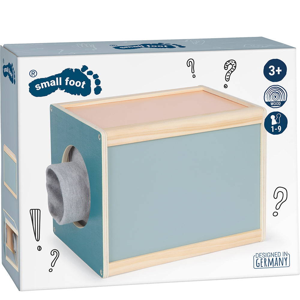 Ein Fühlbox-Sinnesspielzeug aus Holz in einer Schachtel von Small Foot, geeignet für Kinder ab 3 Jahren, mit einem mit einer Socke bedeckten Handloch für ein spannendes taktiles Sinnesspiel.