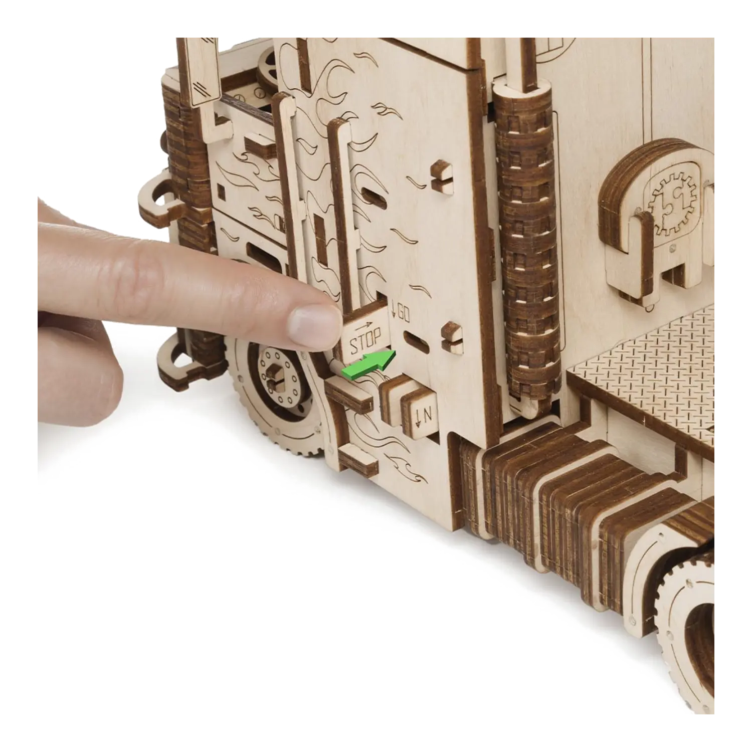 Ein Finger zeigt auf einen STOP-Hebel am 3D-Holzpuzzle Road King LKW mit Container.