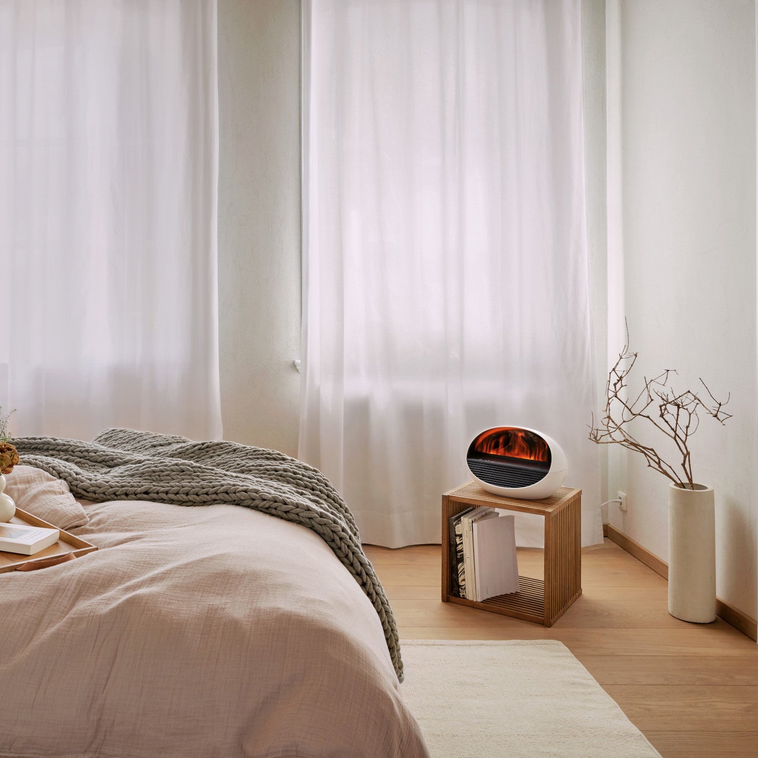 Ein gemütliches Zimmer mit Büchern und dem ERIK Heizlüfter, Aroma Diffuser Effektfeuer