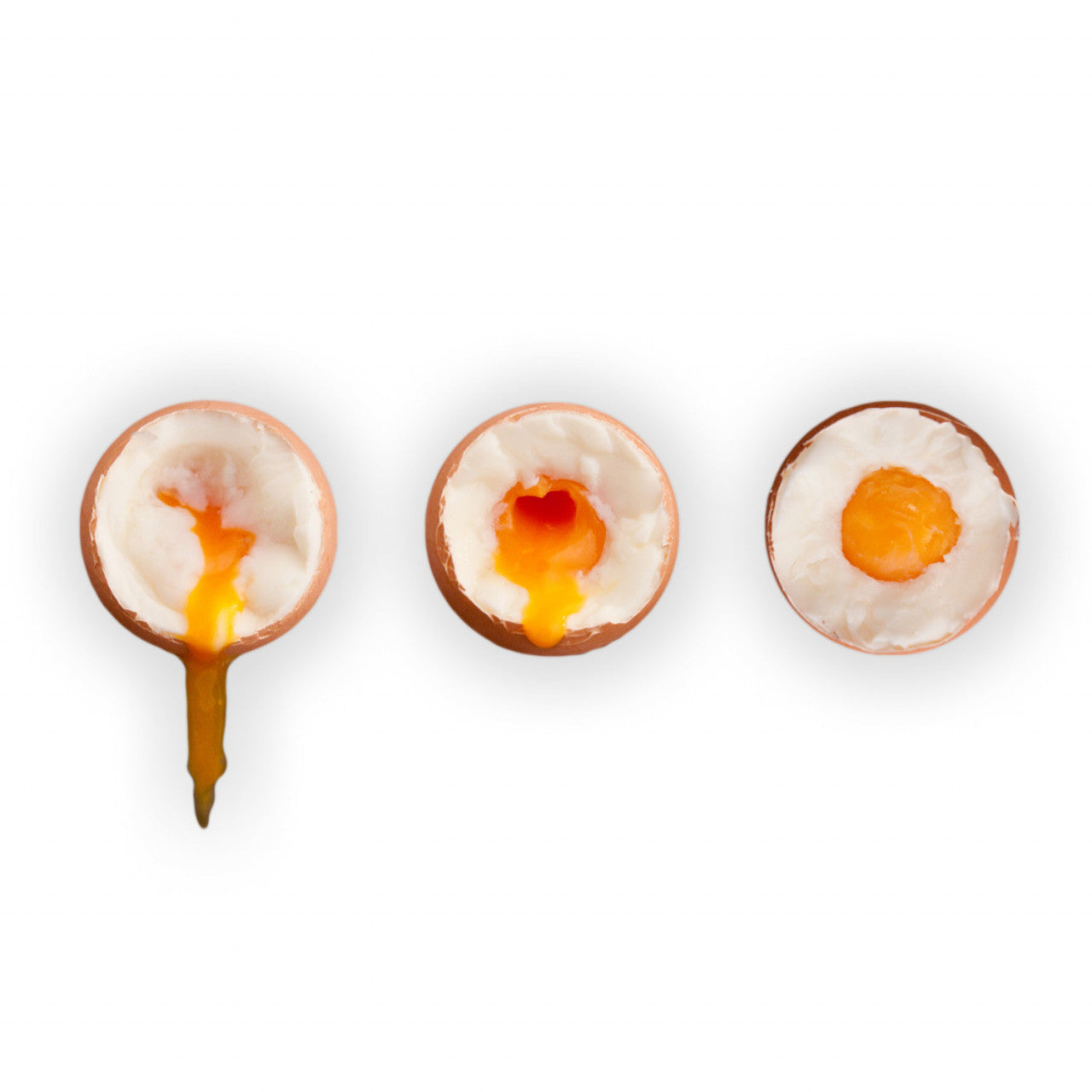 Drei weichgekochte Eier in der Schale, jeweils mit unterschiedlich viel flüssigem Eigelb, auf weißem Untergrund – genau das, was man von smarte PiepEier erwartet, denn damit gelingen jedes Mal perfekt gekochte Eier.