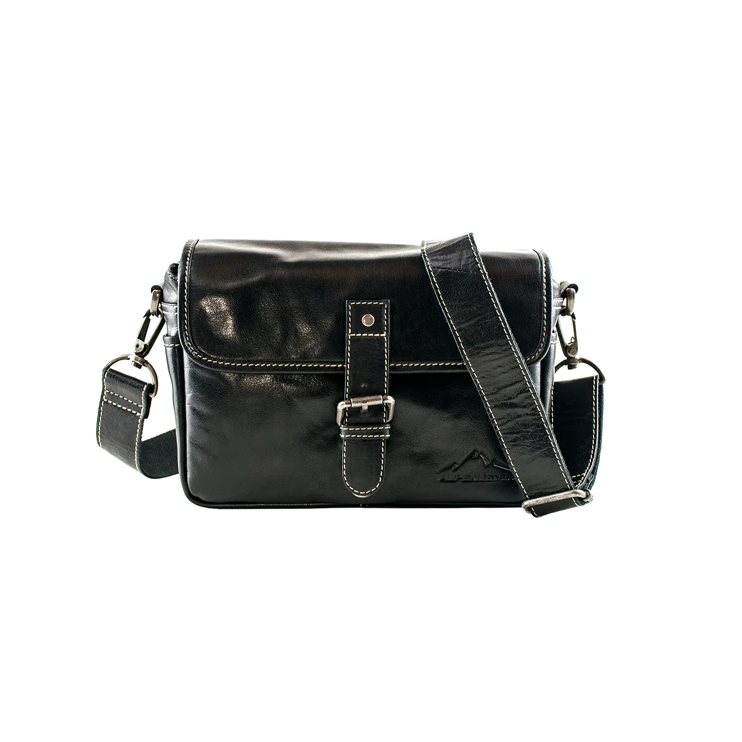 Die Alpenleder Kameratasche PRESSE ist eine schwarze Ledertasche mit Klappdeckel, Schnallenverschluss und weißen Nähten. Sie verfügt über einen abnehmbaren, verstellbaren Schultergurt mit silbernen Beschlägen und eignet sich somit ideal für Hobbyfotografen, um ihre Ausrüstung zu jeder Fotosession mitzunehmen.