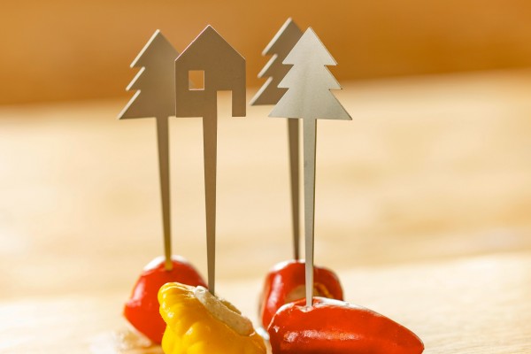 Metallische Zahnstocher in Baum- und Hausform, inspiriert vom SCHWARZWALD SPIESSER Partyspießer, stecken in gelben und roten Paprikastücken – perfekt für bewusstes Essen bei Ihrer nächsten Zusammenkunft.