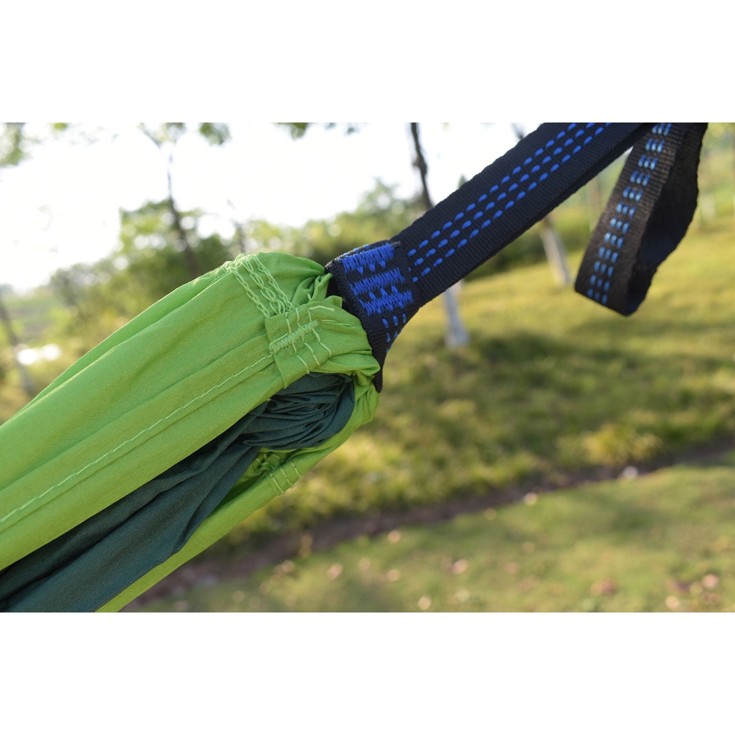 Nahaufnahme einer Hängematte Outdoor, die mit einem blauen Band an einen Baum gebunden ist.