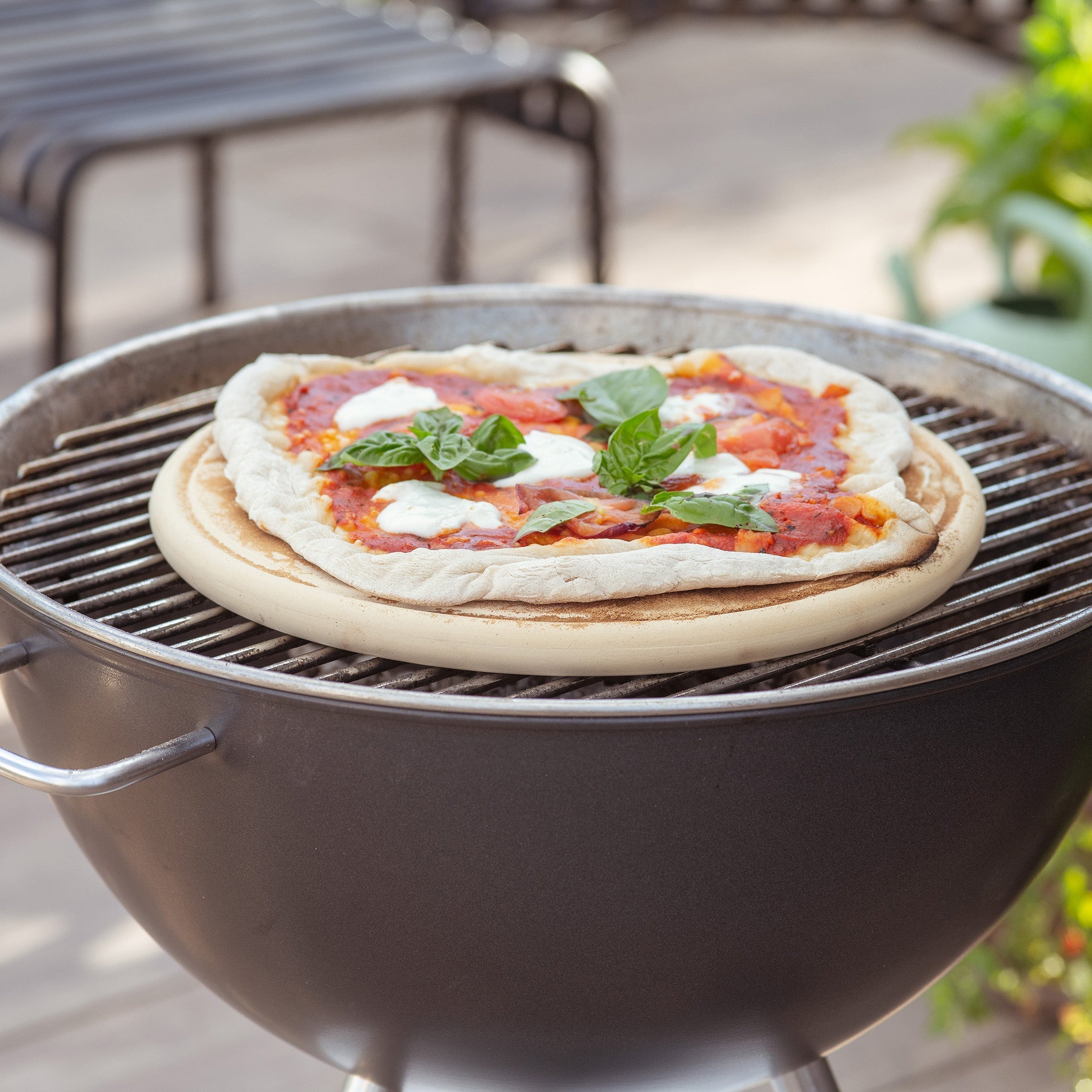 Pizzaplatte von Denk Keramik mit Pizza auf dem Kugelgrill im Garten