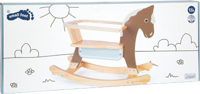 Schaukelpferd aus Holz mit Sitzring auf weißer Box mit gezeichneter Szenerie.