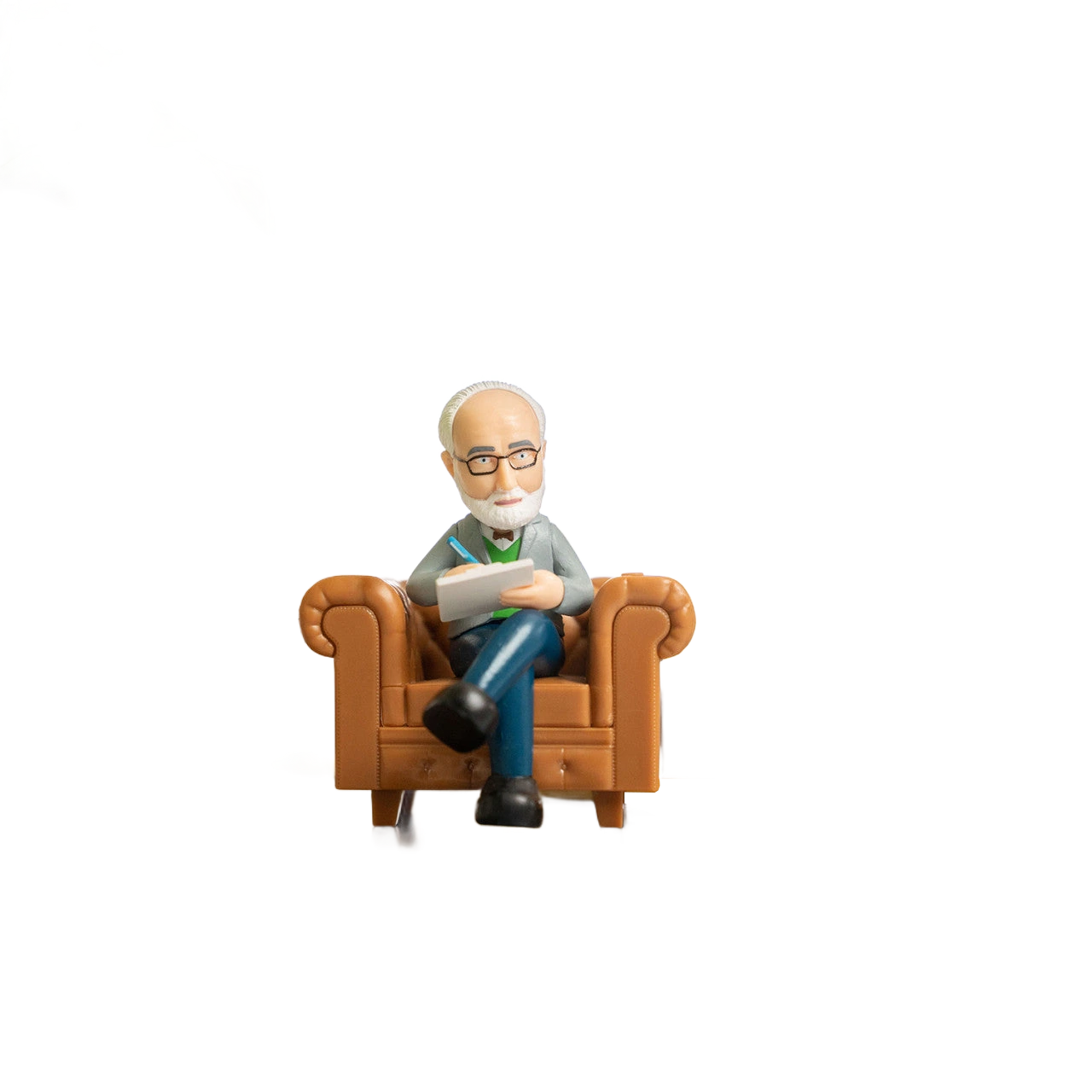 Schreibtisch-Psychologe Spielzeugfigur lesend in einem braunen Sessel auf weißem Hintergrund.