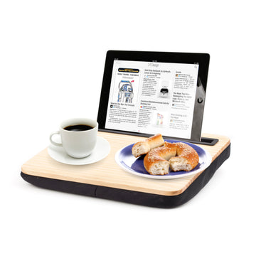 Ein Tablet, eine Tasse Kaffee und ein Teller Bagels liegen auf einem iBed Lap Desk mit einem Kissen darunter und bieten eine gemütliche Einrichtung mit integrierter Tablet-Halterung für freihändigen Komfort.