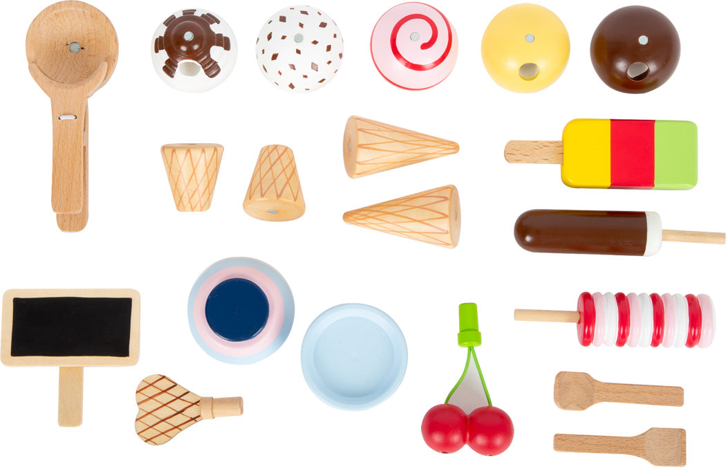 Verschiedene bunte Desserts, Eissorten und Utensilien aus Holzspielzeug – darunter ein Eis-Spielset mit magnetischem Eisportionierer – hübsch auf weißem Hintergrund arrangiert.