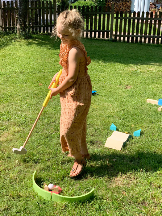 Junges Mädchen spielt draußen Minigolf mit Minigolf Set für Kinder "Active".