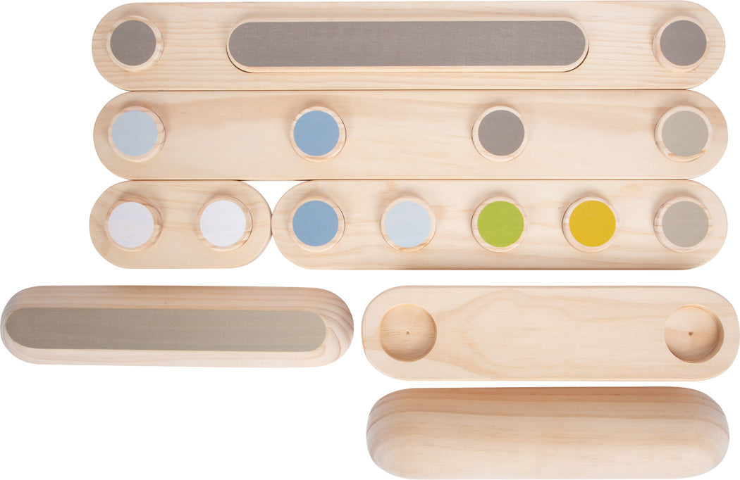 Hölzerne Sinnes-Klangbausteine mit farbigen Kreisen und strukturierten Oberflächen, ideal zum Bauen von Balancierpfaden zur Förderung des Gleichgewichtssinns und Stärkung des Gleichgewichtssinns, angeordnet auf weißem Untergrund.