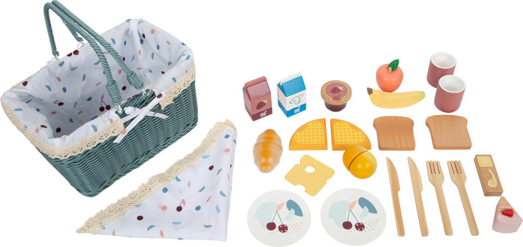 Spielzeug-Picknickset mit einem grünen Picknickkorb, Spiellebensmitteln, Geschirr, Besteck, Bechern und einer Serviette, ordentlich angeordnet – perfekt als Spielset für die Kleinen zum Spaß auf ihrer eigenen Picknickdecke.