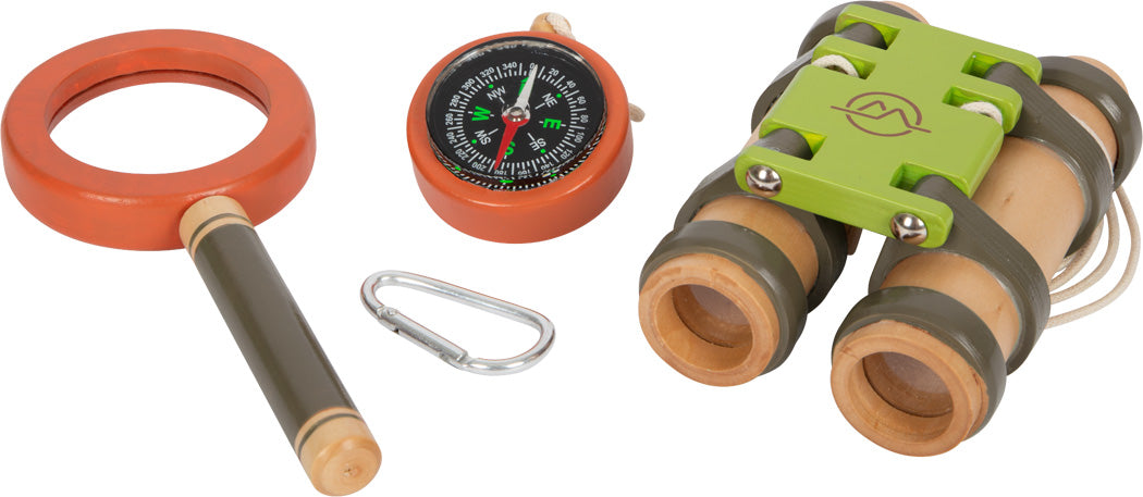 Eine Lupe, ein Kompass, ein Karabiner und ein Fernglas – unverzichtbares Entdeckerspielzeug für spannende Abenteuertouren – liegen ordentlich auf weißem Hintergrund bereit, perfekt zum Verstauen im Rucksack.