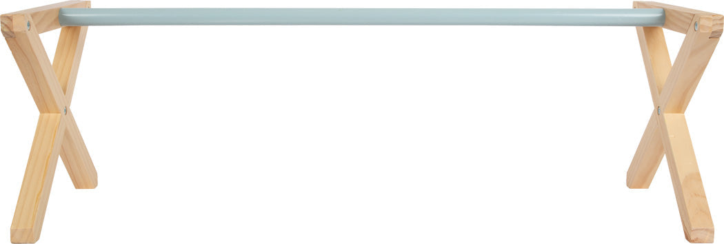 Holztisch mit gekreuzten Beinen aus hellem Holz und einer hellblauen rechteckigen Tischplatte, die von vorne betrachtet an Cavaletti-Hindernisse aus dem Hobby Horsing erinnert.