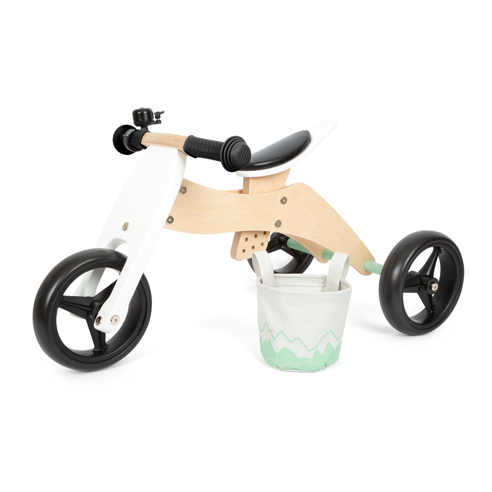 Laufrad-Trike aus Holz mit schwarzen Rädern, schwarzem Lenker und einem kleinen weißen Korb mit grünem Muster auf der Vorderseite – perfekt für Gleichgewicht und sichere, spielerische Abenteuer.