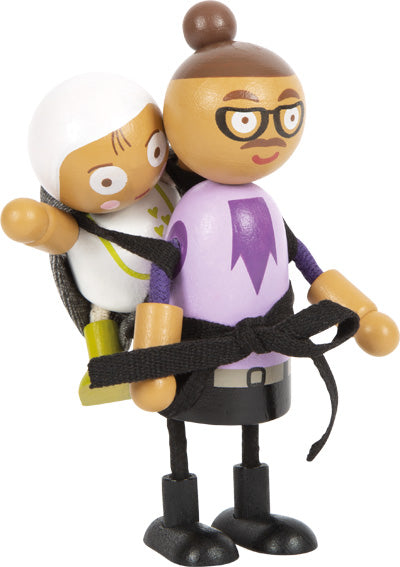 Biegepuppenfigur aus Holz mit Brille, die eine Babypuppe in einer schwarzen Stofftrage auf dem Rücken trägt, perfekt für jedes Puppenhaus- oder Patchwork-Familien-Spielszenario.