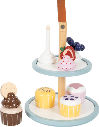 Cupcake-Etagere aus Holz mit zwei Etagen, ideal für die Kinderküche. Enthält Cupcakes, eine Kerze, Obst und einen Keks obendrauf.