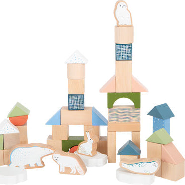 Holzbausteine aus diesem Holzbaustein-Set und arktische Tierfiguren werden zu kleinen Strukturen auf einem weißen Hintergrund angeordnet und schaffen so ansprechendes motorisches Spielzeug für fantasievolles Spielen.