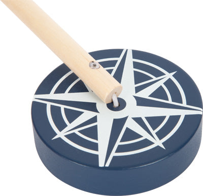 Dieser Stapelturm von Holzspielwaren besteht aus einem Holzstab, der an einer blauen, runden Basis mit einem weißen nautischen Kompassdesign befestigt ist und ein charmantes und spannendes Motorikspielzeug für Kinder darstellt.