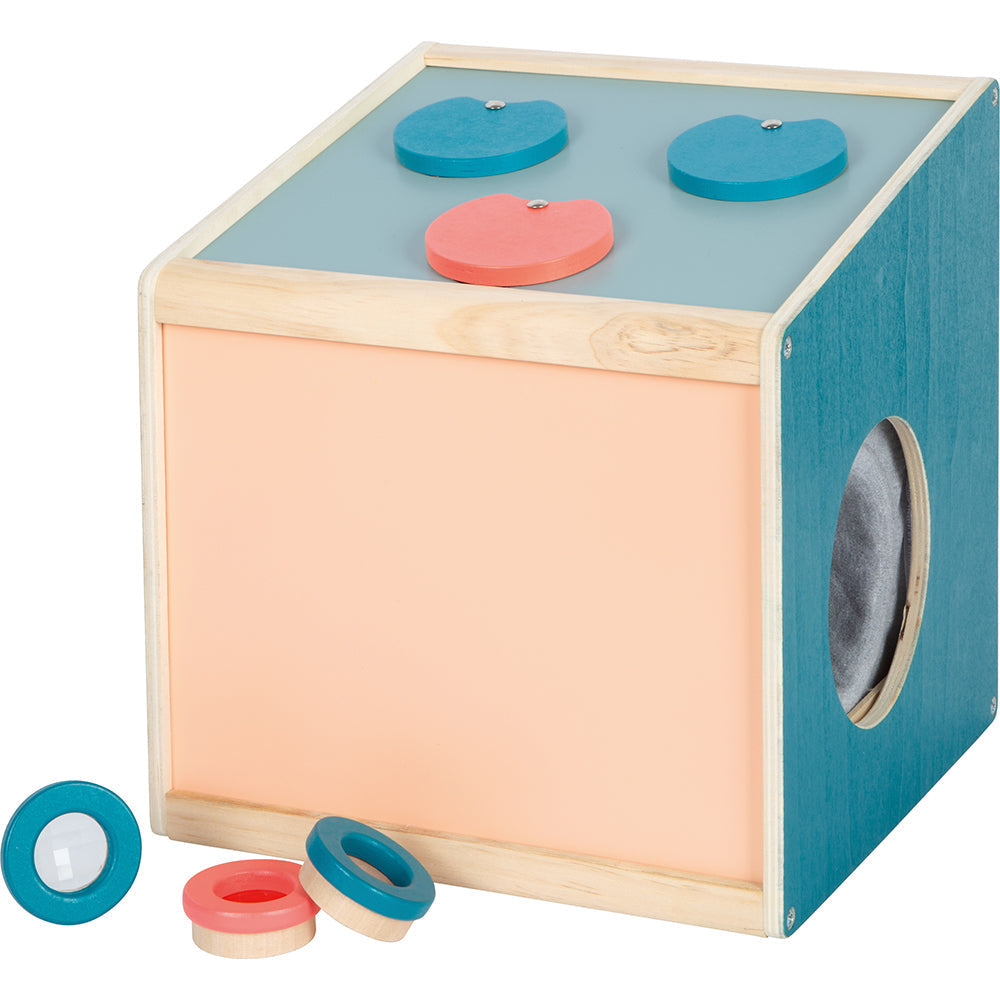 Sensorische Formsortierbox aus Holz, inspiriert von einer Sinnes- und Fühlbox, mit farbigen Herz- und Kreisteilen oben und einer seitlichen Öffnung zum taktilen Erkunden.