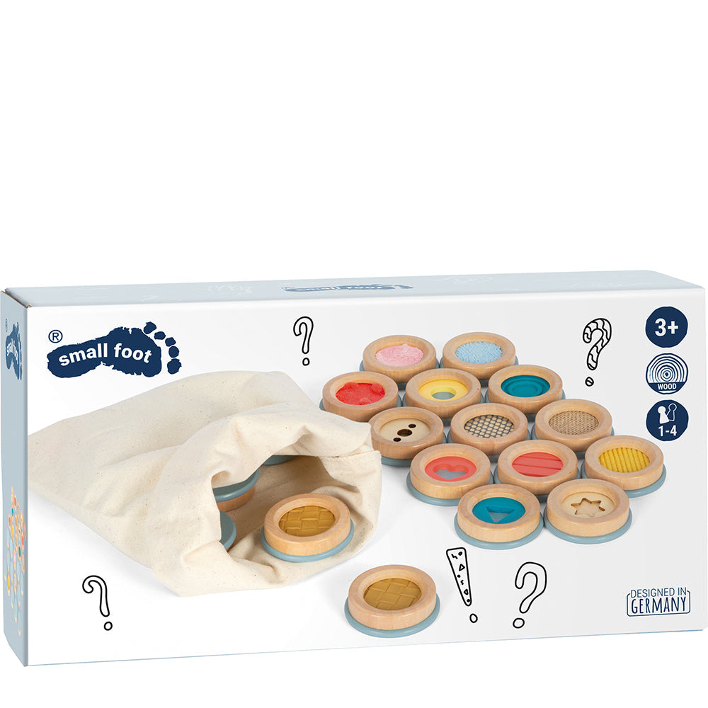 Box eines Sinnesspiel-Sets mit Holzscheiben und Stofftasche, perfekt als taktiles Gedächtnisspiel für Kinder ab 3 Jahren.