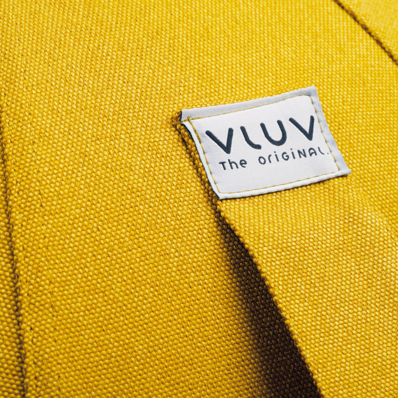 Eine Nahaufnahme eines VLUV BOL LEIV Stoff-Sitzballs in Senffarben mit Etikett.