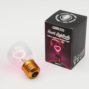 Kabellose Edison-Glühbirne in Herzform mit goldenem Sockel neben ihrer stilvollen schwarz-rosa Verpackungsbox.