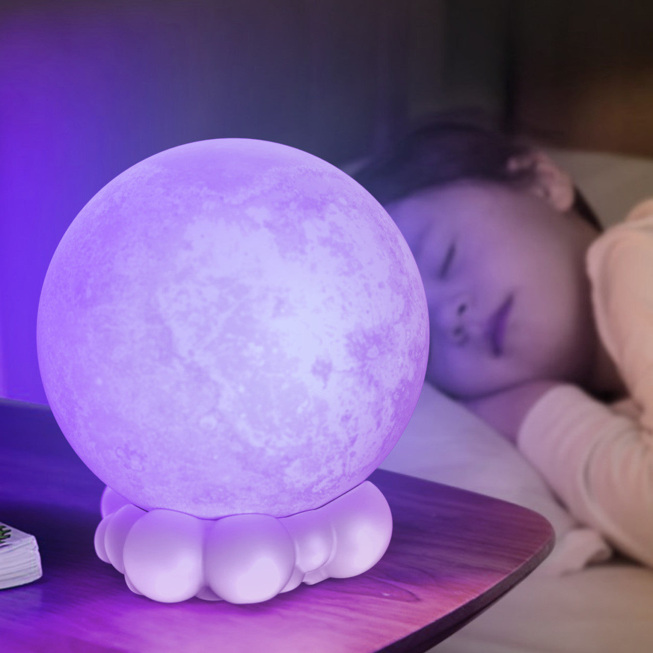 Ein Kind schläft neben einer leuchtenden, 3D-gedruckten lila Mondlampe auf einem Nachttisch, die ein sanftes Nachtlicht wirft.