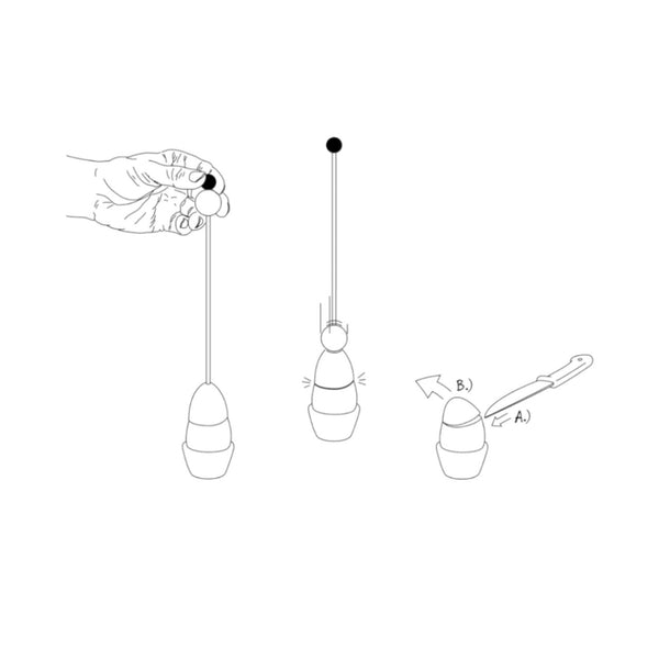 Eine Hand hält eine Schnur mit einem Ball neben zwei Kreiseln – einer wird mit einem Stock gestartet, und daneben glänzt ein Eieröffner wie Edelstahl.