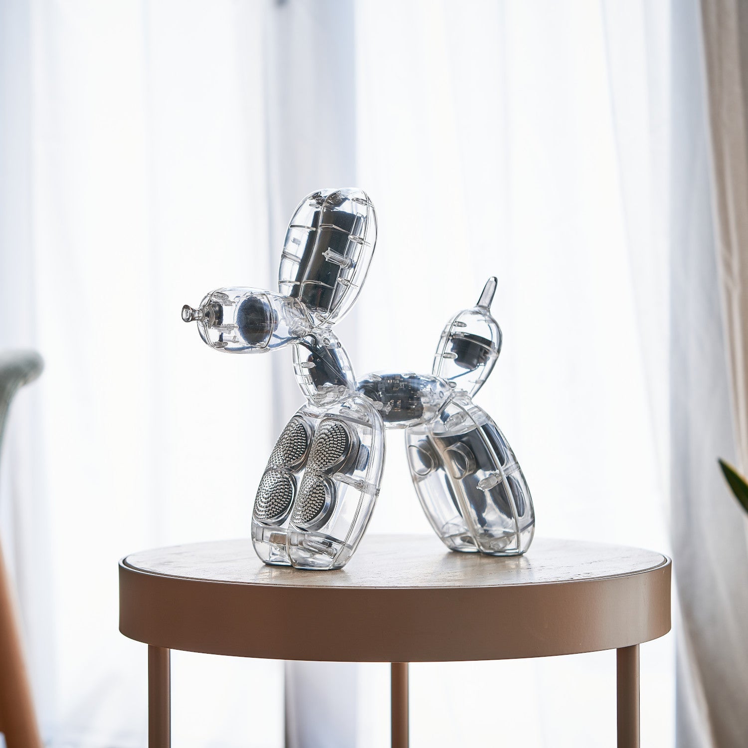 Ein durchsichtiger Balloon Dog Lautsprecher von Jeff Koons - Acryl steht auf einem hellen Tisch.