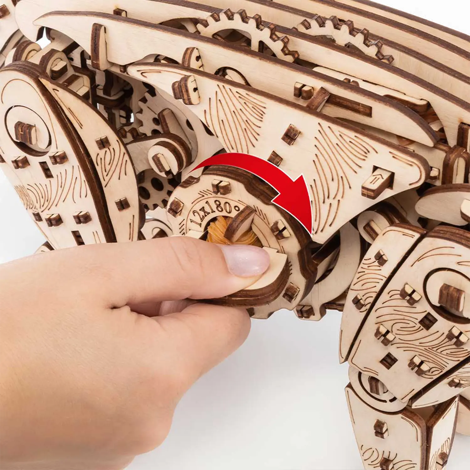 Drehen eines hölzernen Zahnrades von Hand auf 3D-Holzpuzzle Mechanische Katze, natur.