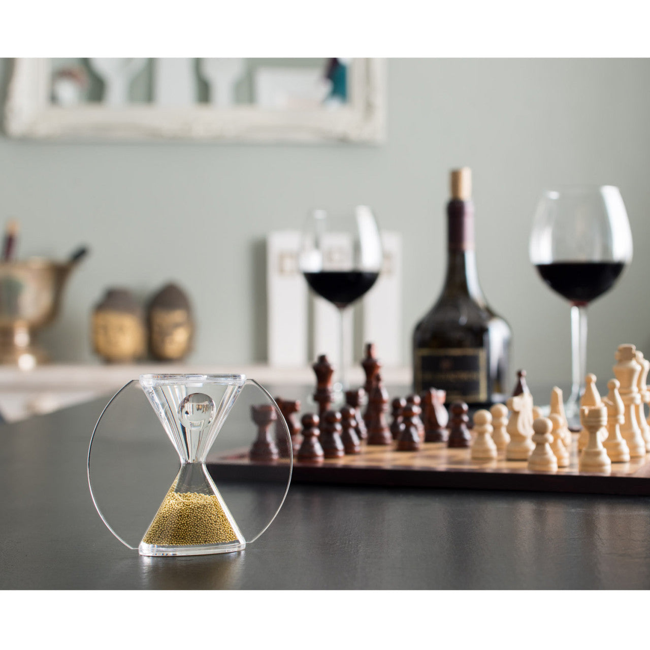Eine Paradoxe Oper Sanduhr - Goldglasperlen und Schachbrett mit Weingläsern.