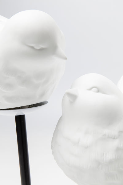 Zwei glatte, weiße Vogelfiguren aus Keramik, die sich vor einem hellen Hintergrund gegenüberstehen, verleihen jedem Raum einen Hauch von elegantem Design.