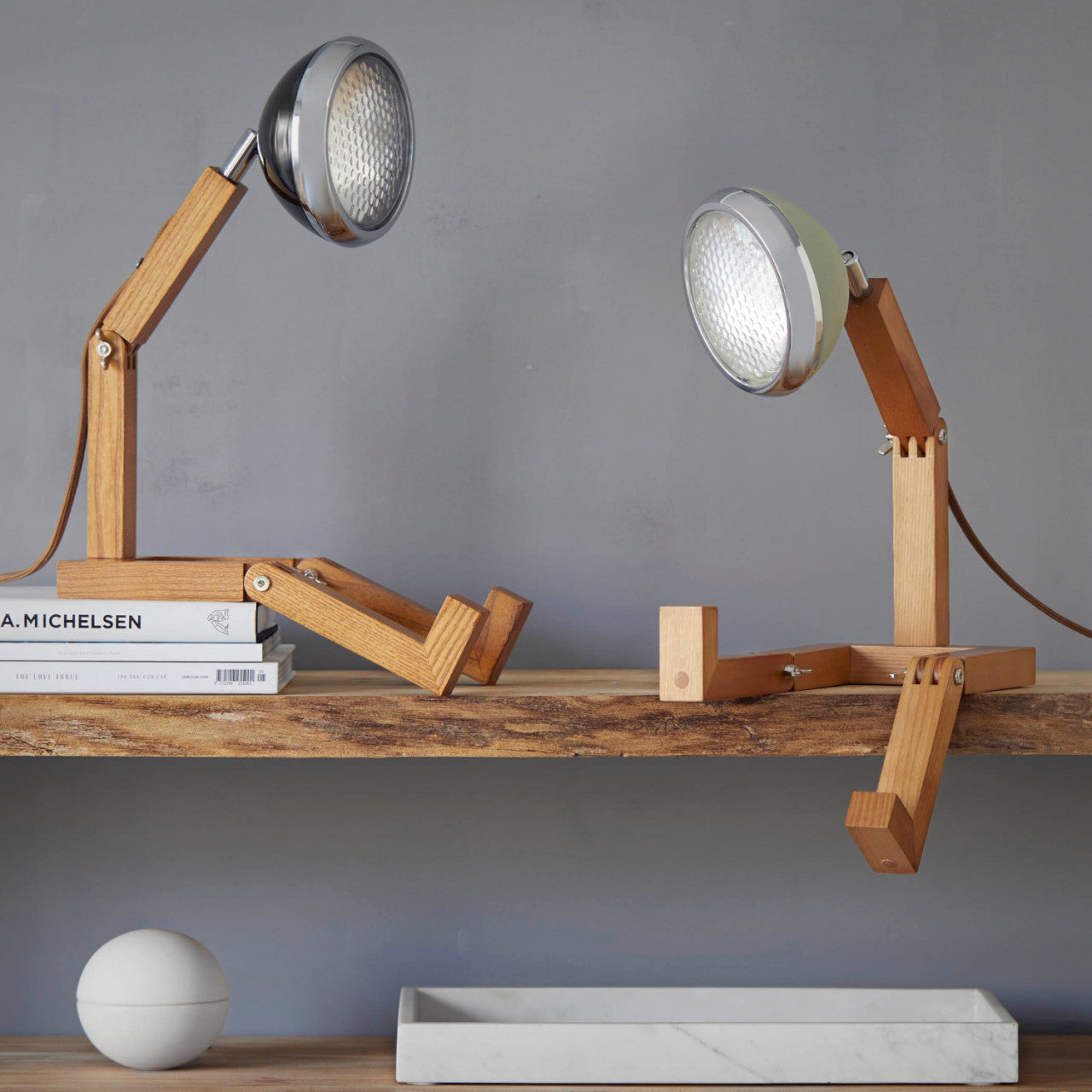 Zwei Mr. Wattson LED Lampe - Fashion schwarz auf einem Regal, geformt wie Menschen.