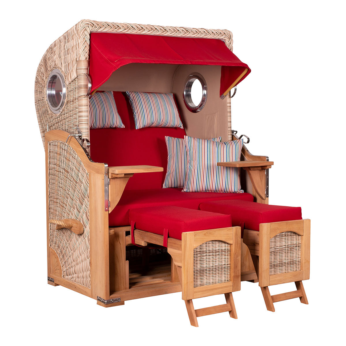 Strandkorb aus Korbgeflecht mit roten Auflagen, Fußstützen und bunt gestreiften Kissen.