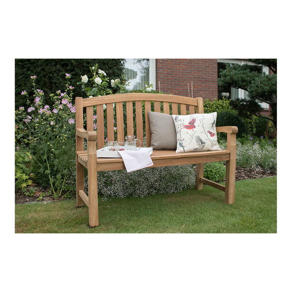 Teakbank aus Naturholz mit bequemen Kissen und einem Tablett voller Gläser, perfekt für die stilvolle Outdoor-Gestaltung im Garten zwischen blühenden Blumen auf dem Rasen.