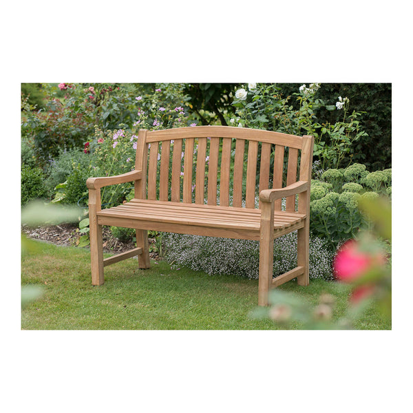 Eine Teakbank aus Naturholz steht auf einem grünen Rasen, umgeben von blühenden Pflanzen – ein harmonischer Mittelpunkt der Outdoor-Gestaltung.