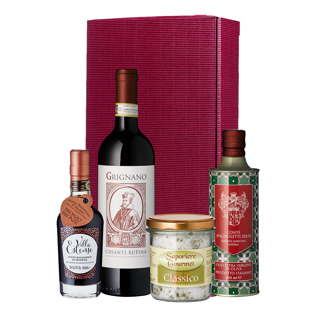 Geschenkpaket Schlaraffenland: Chianti Rufina, Balsamico di Modena, Olivenöl Extra Vergine und Edelsalz stilvoll vor einer roten Box arrangiert.