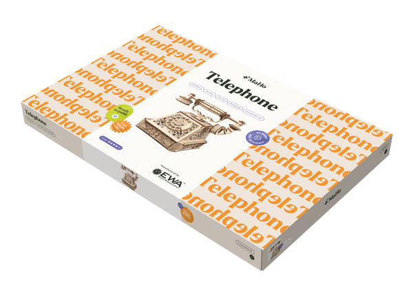 Die Verpackung eines Holzmodellbausatzes zeigt ein antikes Telefon mit dem Wort "Telephone" in großen Buchstaben darauf sowie mehreren dekorativen Elementen und Schriftzügen.
