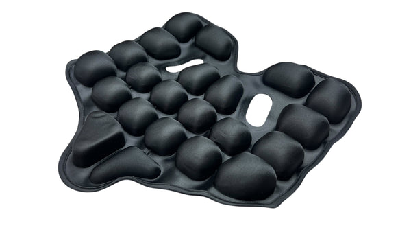 Ein schwarzes Sitzkissen mit mehreren erhabenen  weich gepolsterten Beulen in einem unregelmäßigen Muster.
